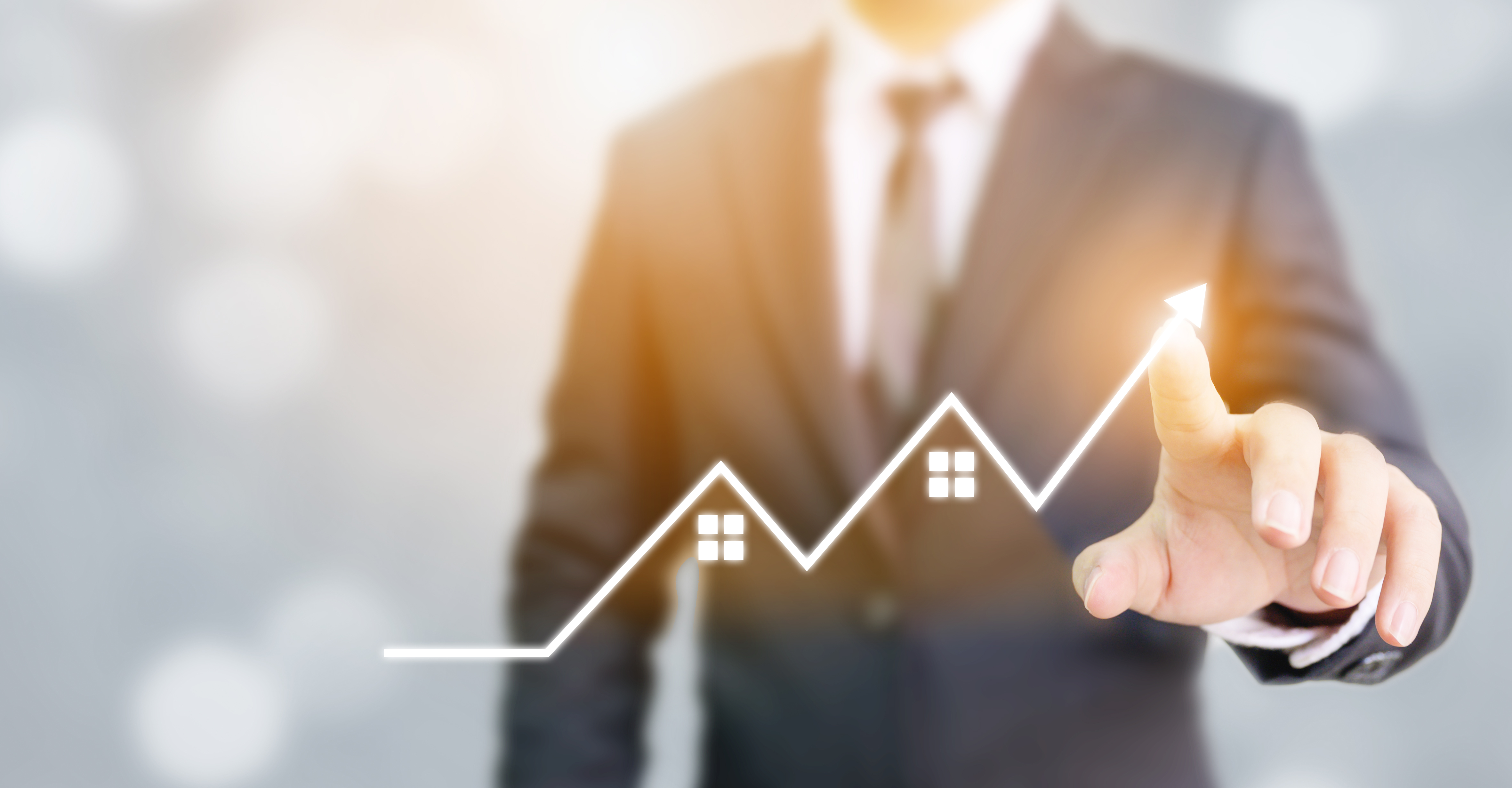 Man using his finger to draw a line chart going up