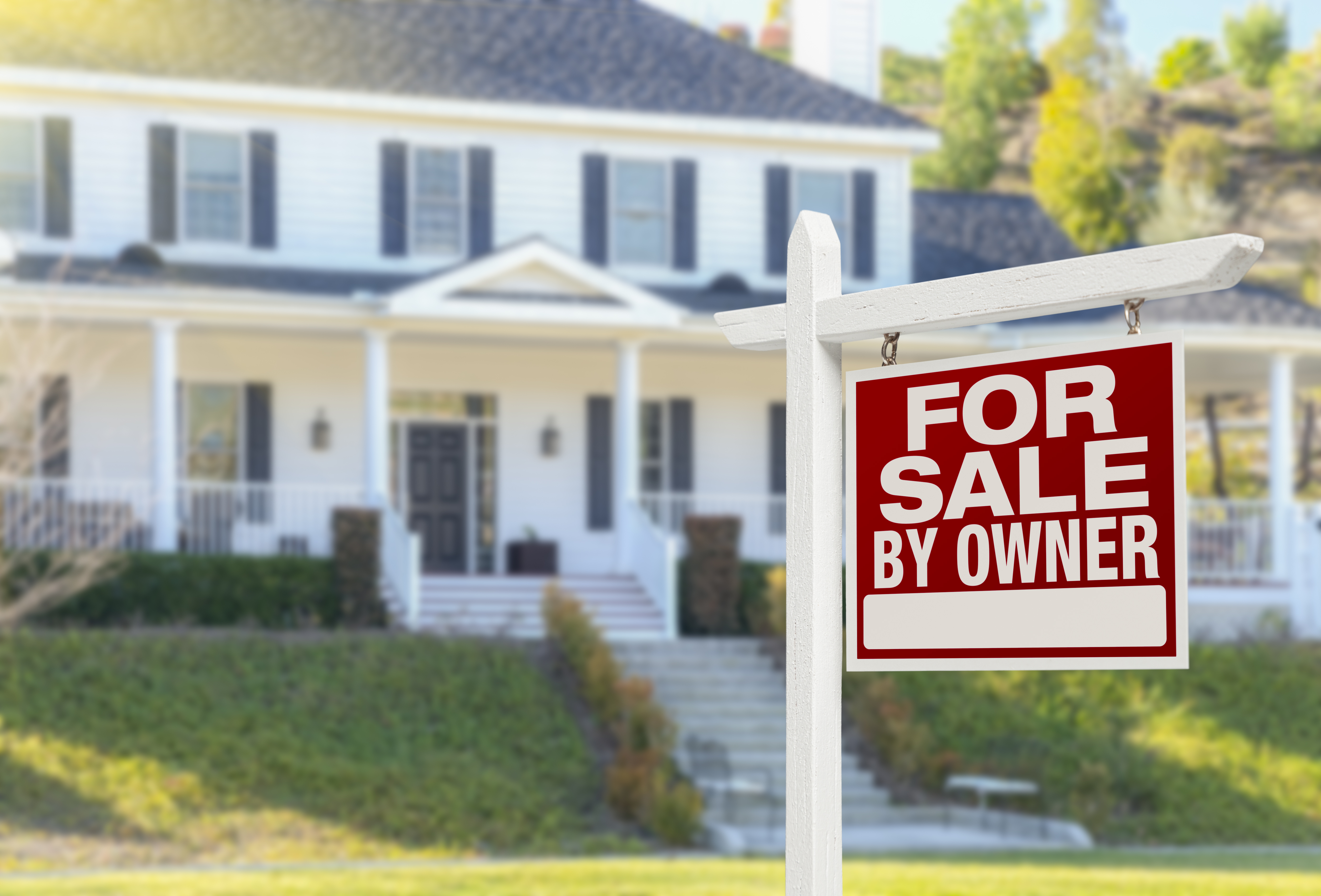 House with a for sale by owner sign