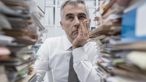 Man with stacks of folders in front of him